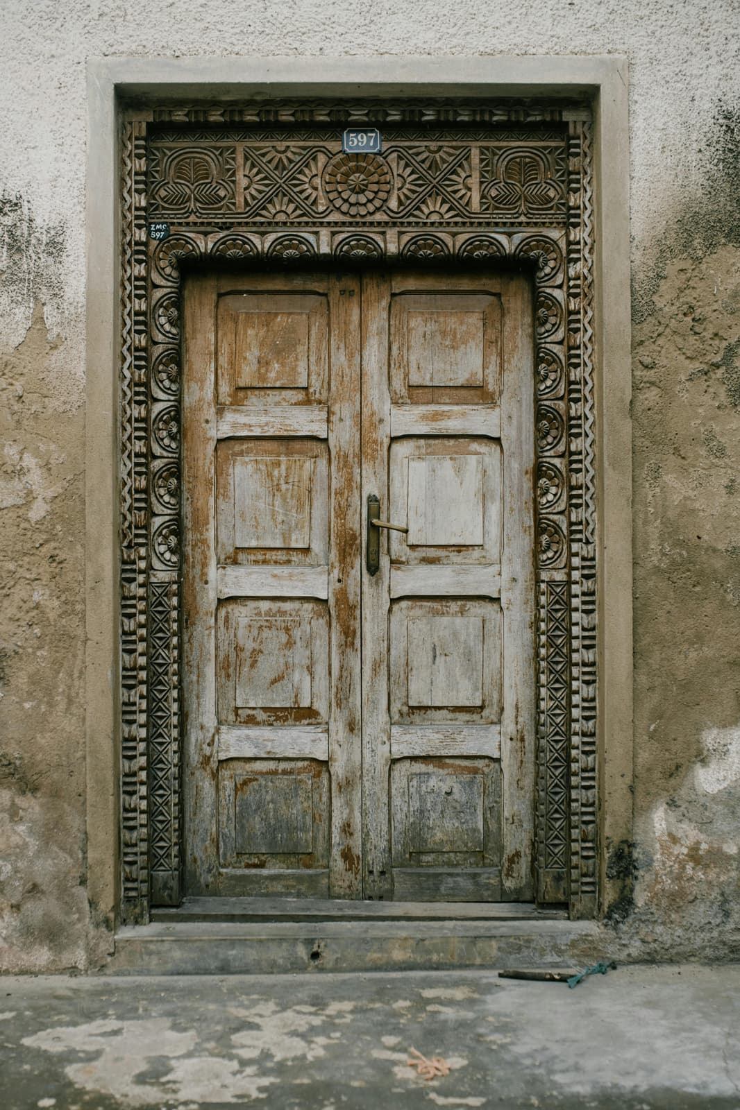 Weathered carved wooden door in a Stone Town alley